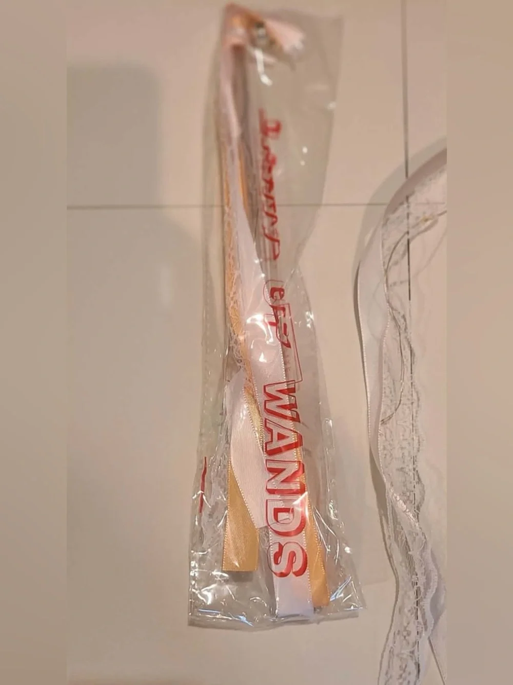 50 individually wrapped LED wands with Champagne ribbon and white lace with bell